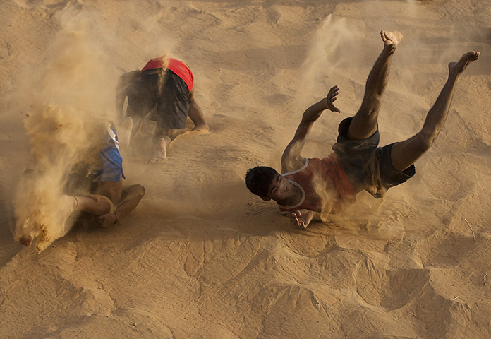 24 hours: Bhiwani, India: Boxers roll down a sand dune during training