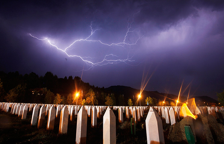 24 hours: Potocari, Bosnia: Lightning flashes during a storm at the memorial centre