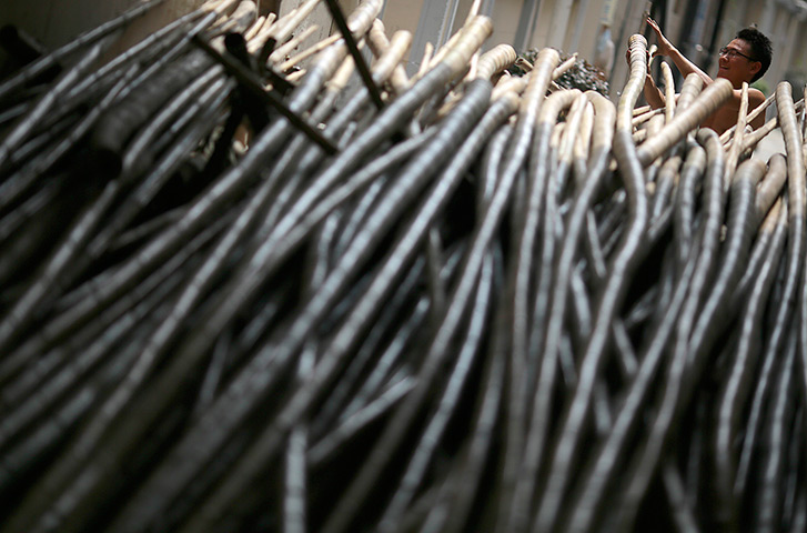 24 hours: Shanghai, China: A worker gathers scaffold bamboo at a construction site