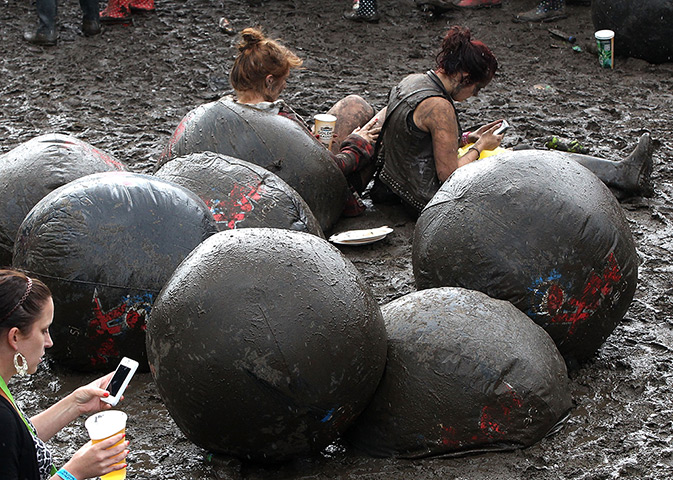Wet festivals update: Two girls sit in the mud at Wireless Festival at Hyde Park 