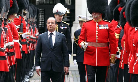 Feeling small … Francois Hollande inspects the guard of honour by the Coldstream Guards.