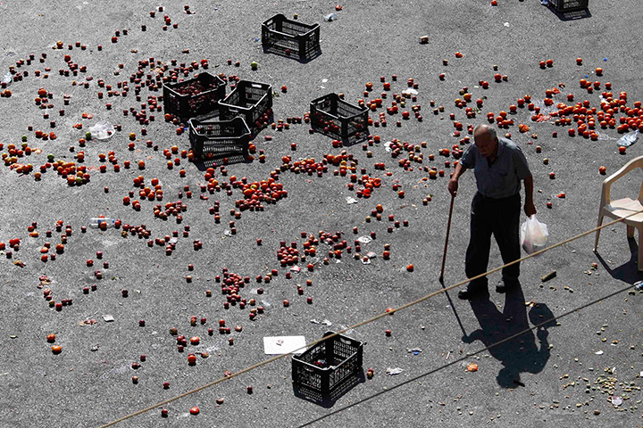 24 hours: Sidon, Lebanon: A man walks past produce thrown on a road