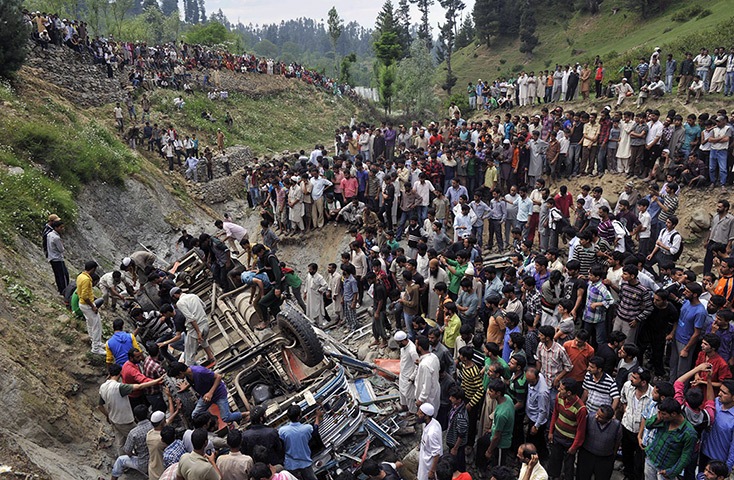 24 hours: Nambal Nard, Kashmir, India: Villagers stand near a crashed bus
