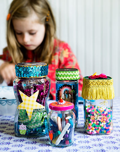 Brita craft: Girl playing behind decorated jam and coffee jars