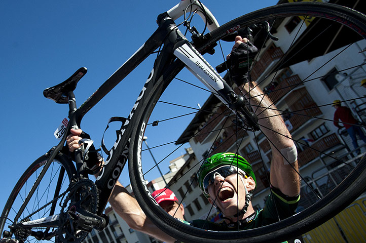 tour de france: Pierre Rolland lifts his bicycle as he celebrates winning the stage