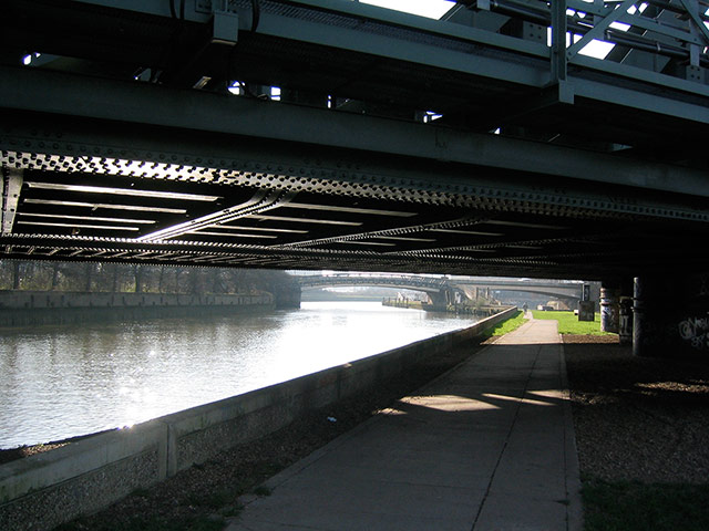 Olympic architecture: a path runs under a bridge along water