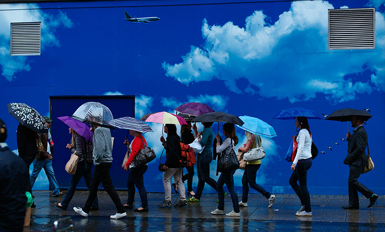 Week in business: People shelter from the rain under umbrellas on Oxford Street