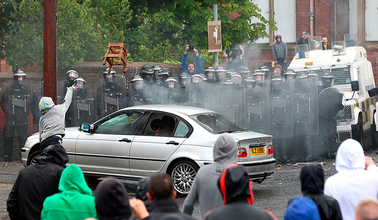 Picture Desk Live: A youth throws a chair over a burning car in Northern Ireland