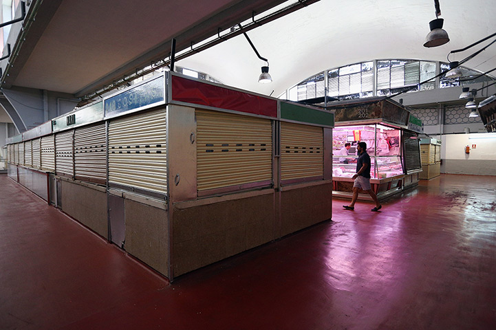 Week in business: Closed stalls in an indoor market in Madrid