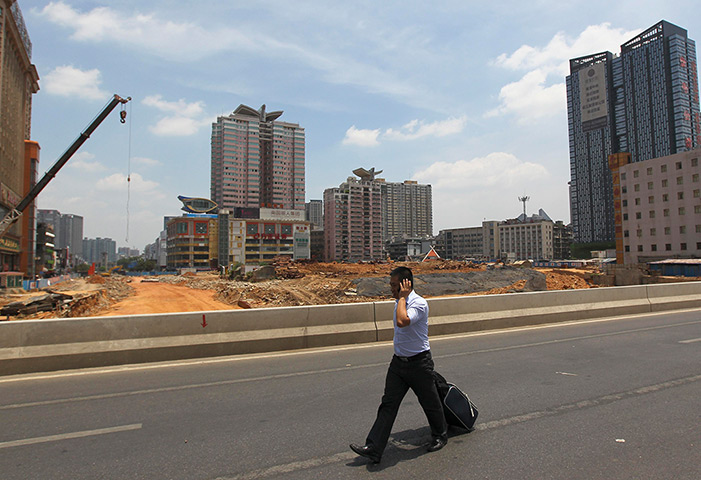 Week in business: A man walks past a residential construction site in Changsha