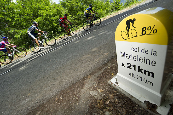tour de france: The leading men ride past a roadsign 