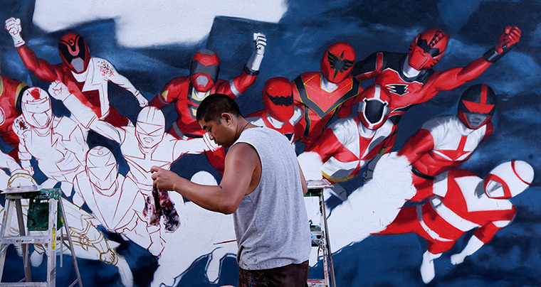 Comic con: Artist Swank One grabs a towel as he paints Power Rangers on a wall