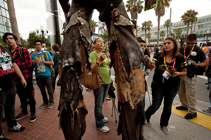 Comic con: Attendees interact with stilt walkers