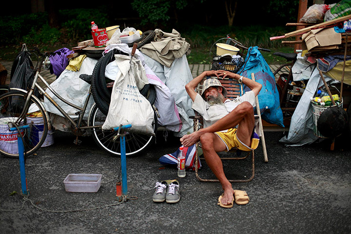 24 Hours: Shanghai, China: A bicycle repairman sleeps on a chair