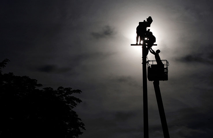 24 Hours: Manila, Philippines: Workers attach LED lights to a lamppost