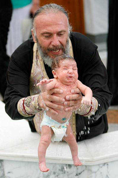 Picture Desk Live: A baby is baptised during a mass baptism ceremony in Tbilisi