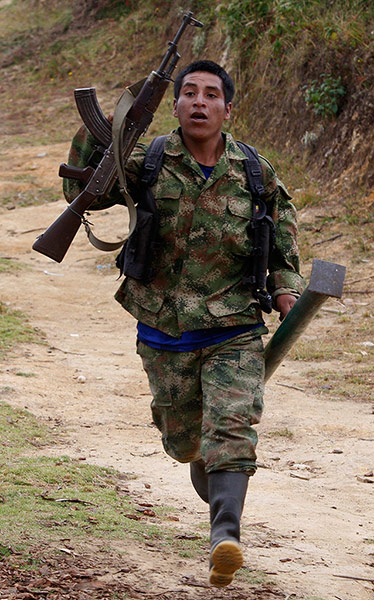 FARC in Colombia: FARC member runs during a battle with the Colombian Army 