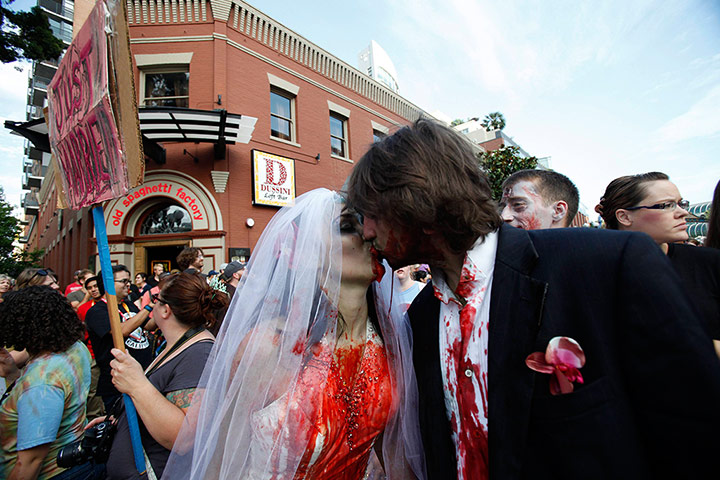 Comic-con: A couple dressed up as zombies kisses during a zombie walk