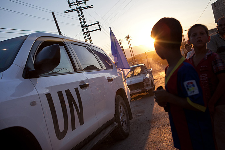 Tremseh, Syria: Residents gather around the vehicles of UN observers