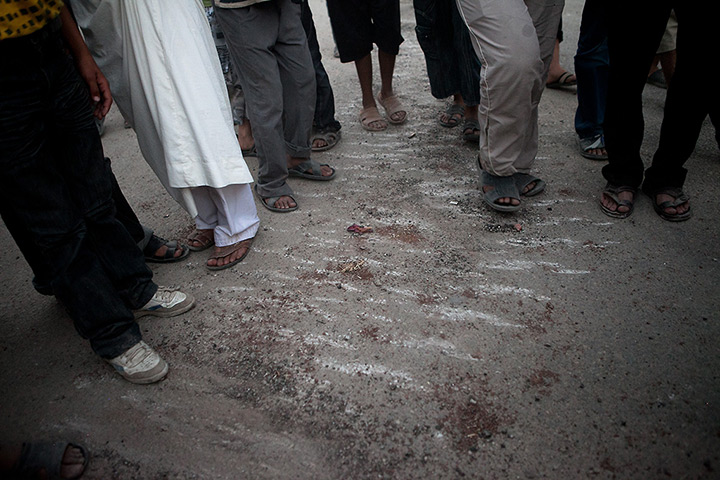 Tremseh, Syria: Syrians stand next to the tracks of army tanks in the village 