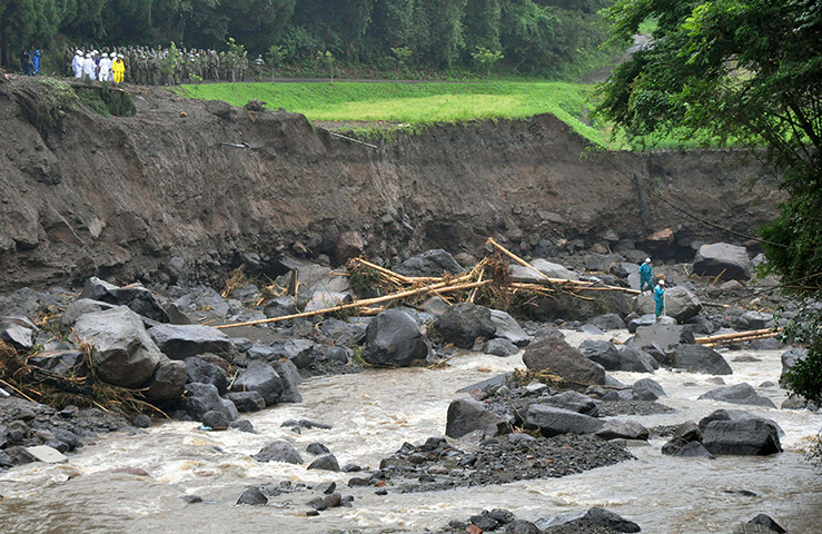 Floods in Japan: rescue workers, right, search for missing people in Taketa, Oita Prefecture