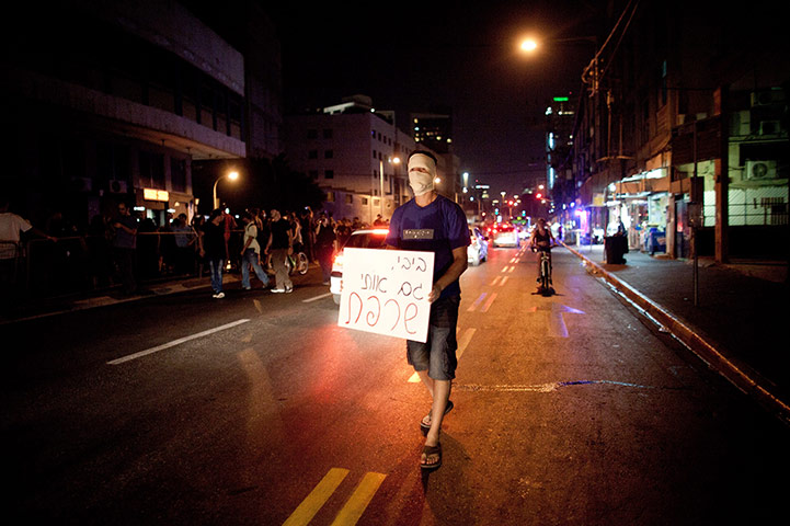 Tel Aviv protests: An Israeli man covers his face with a bandage