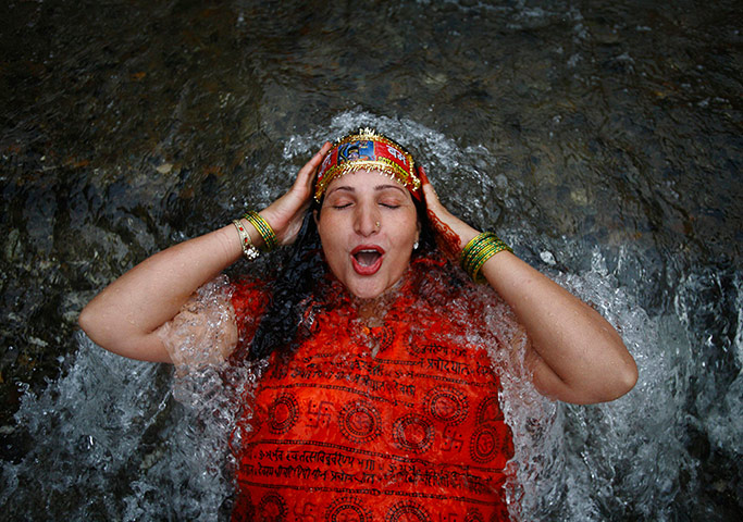 Picture desk live: A Hindu devotee takes a dip at the Bagmati River in Kathmandu