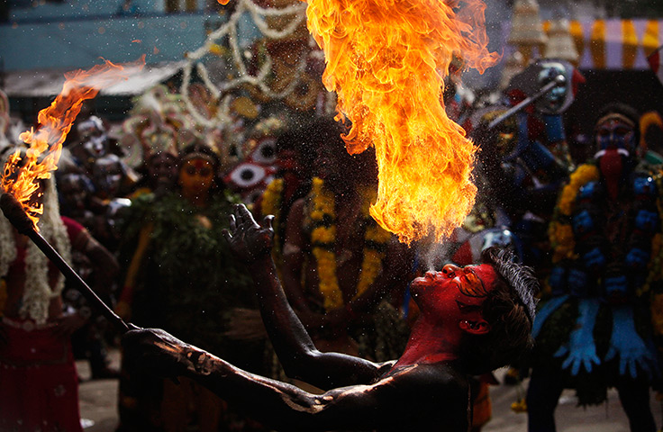24 hours: Hyderabad, India: An Indian artist performs with fire 