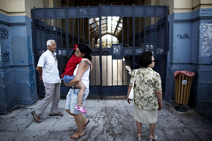 Picture desk live: People pass a closed station in Athens as railway employees strike