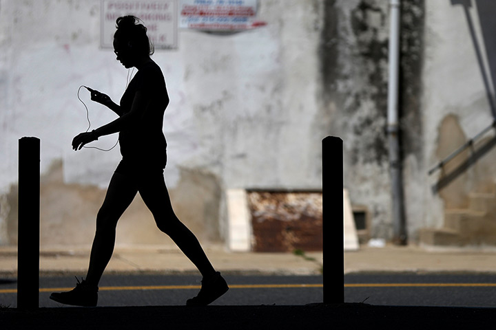 24 hours: Philadelphia, USA: A woman  walks during the midday heat