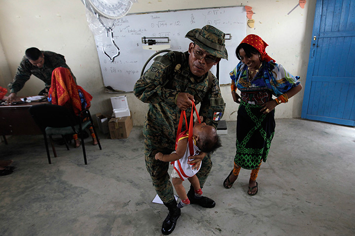 24 hours: Carti, Panama: A border police officer carries an indigenous Kuna baby