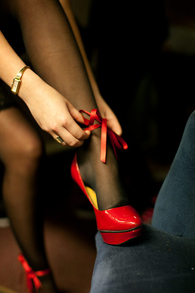 The Windmill Club: Female dancer backstage putting on high heels