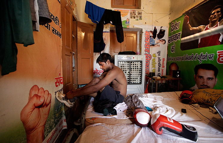 Boxing in India: An Indian amateur boxer gets ready for a training session in his room 