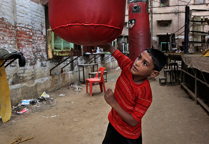 Boxing in India: Rahul a 10-year-old boxing trainee practices with a punching bag