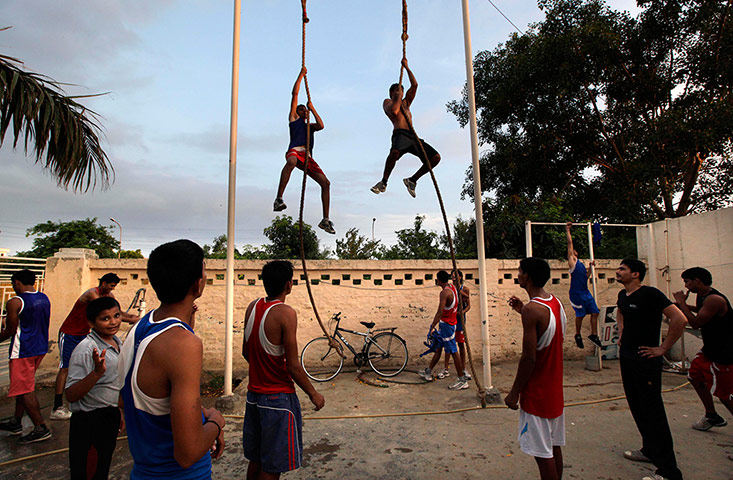 Boxing in India: Indian amateur boxers climb a rope during a training session