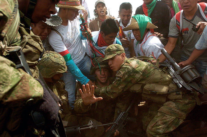 Civil unrest in Colombia: Soldiers try to lift sergeant Rodrigo Garcia as he is attacked