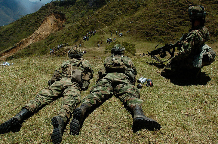 Colombia unrest: Members of the Colombian Army watch a group of indigenous people