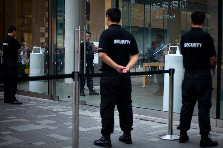 Picture desk live: Security workers guard an entrance of an Apple store Beijing