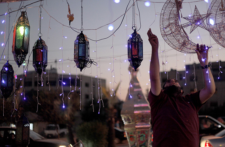24 hours in pictures: A street vendor plugs in decorations for Ramadan