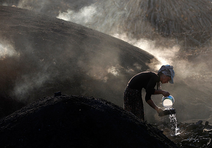 24 hours in pictures: A woman sprays water on burning wood near Kizilcahamam