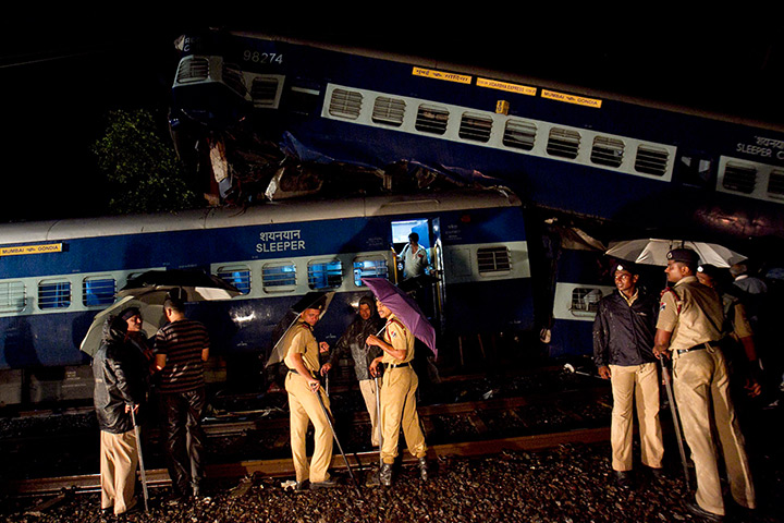 24 hours in pictures: Policemen and rescue workers gather in front of the derailed coaches