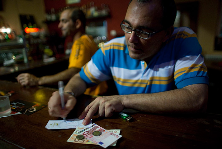 From the agencies: Jose Manuel Abel signs a receipt for his salary as a kitchen assistant