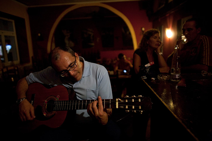 From the agencies: Jose Manuel Abel plays a guitar in the restaurant where he works