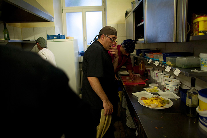 From the agencies: Jose Manuel Abel looks helps prepare plates of food while working