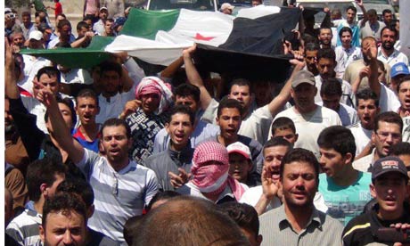 Demonstrators hold an opposition flag during a protest against President Bashar al-Assad in Qara near Damascus