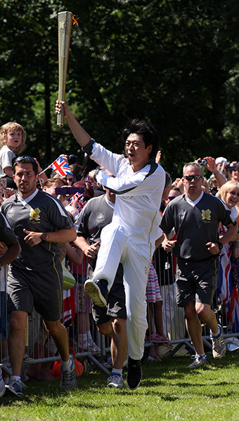 Olympic Torch 65: Lang Lang carrying the Olympic Flame on the Torch 