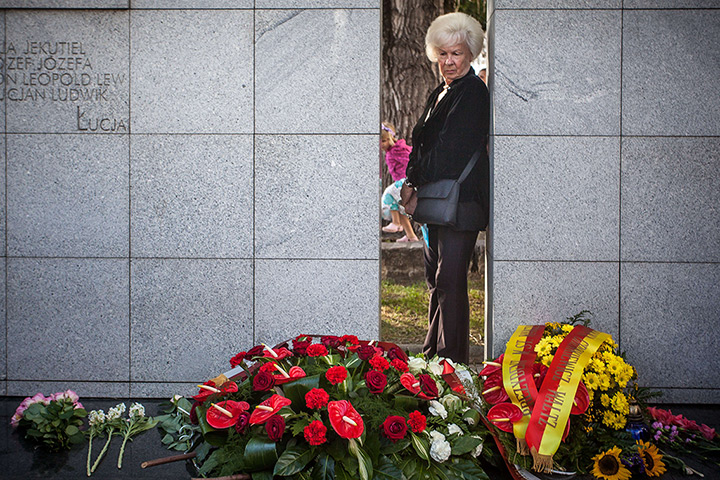 24 hours: Warsaw, Poland: A Polish woman looks at flowers and candlesat a memorial