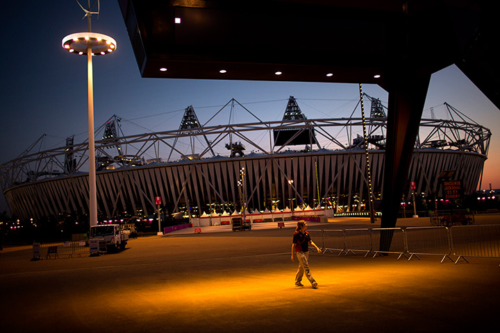 24 hours: London, England: A volunteer walks past the Olympic Stadium 