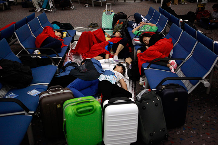 Picture desk live: Passengers sleep near their luggage