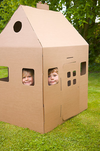 Brita garden games: Cardboard playhouse with children inside in the garden